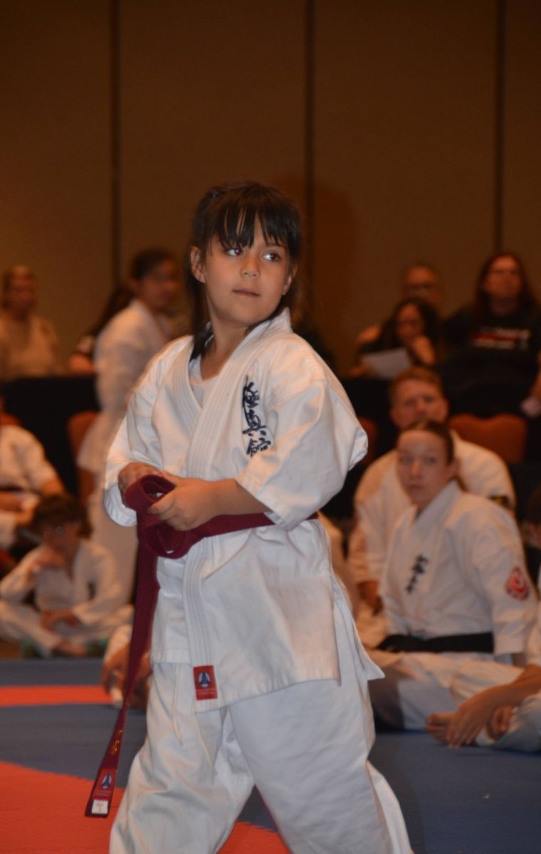 A young student standing ready in her gi